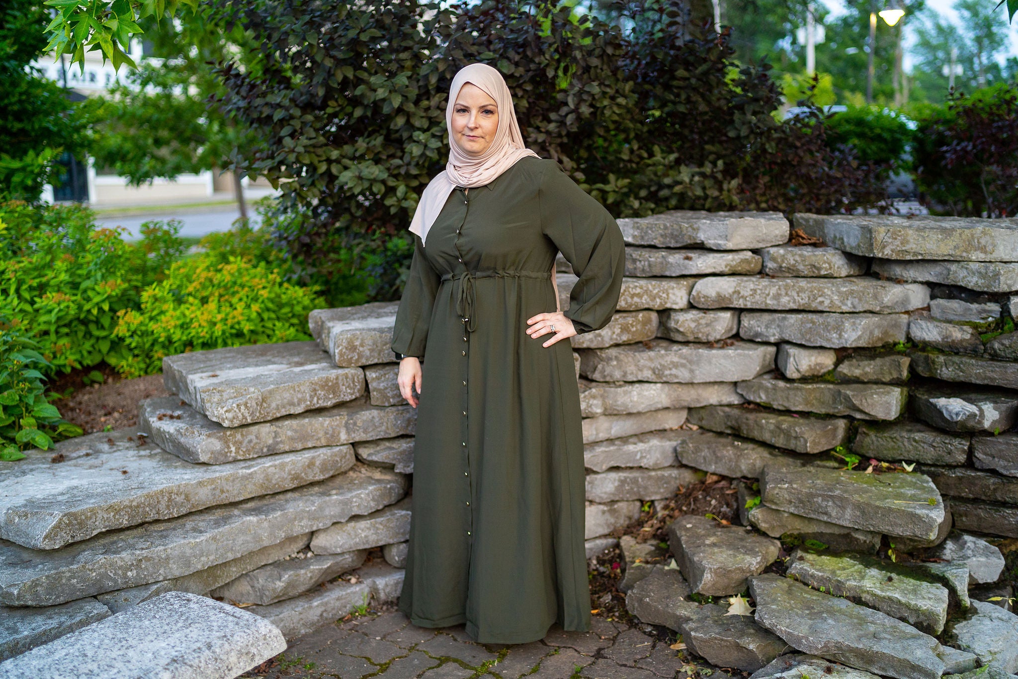 women wearing an abaya/maxi dress with a pointed collar with buttons down the front with a drawstring