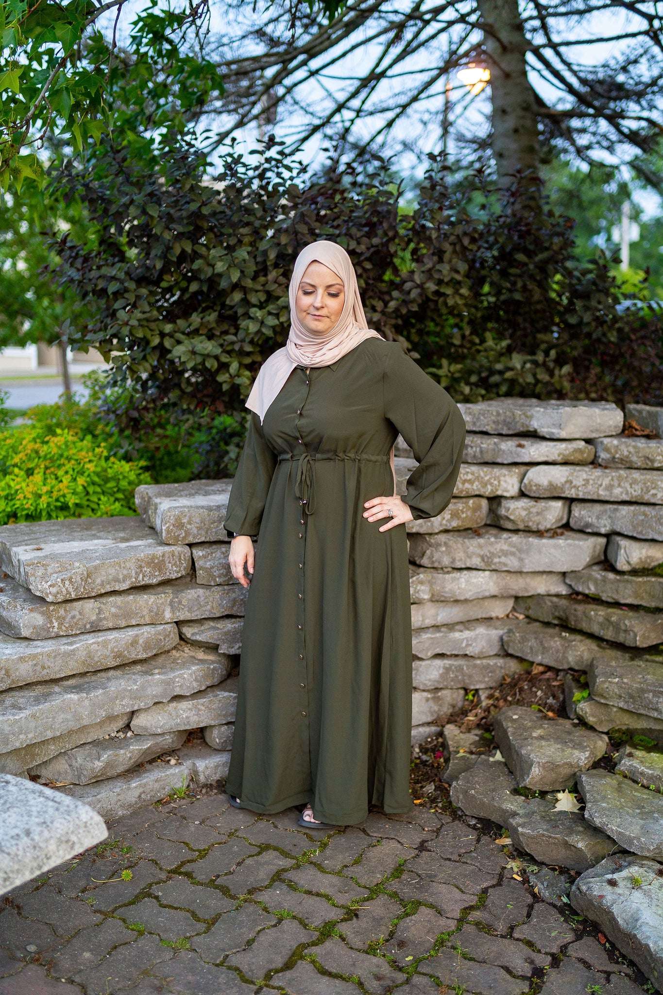women wearing an abaya/maxi dress with a pointed collar with buttons down the front with a drawstring